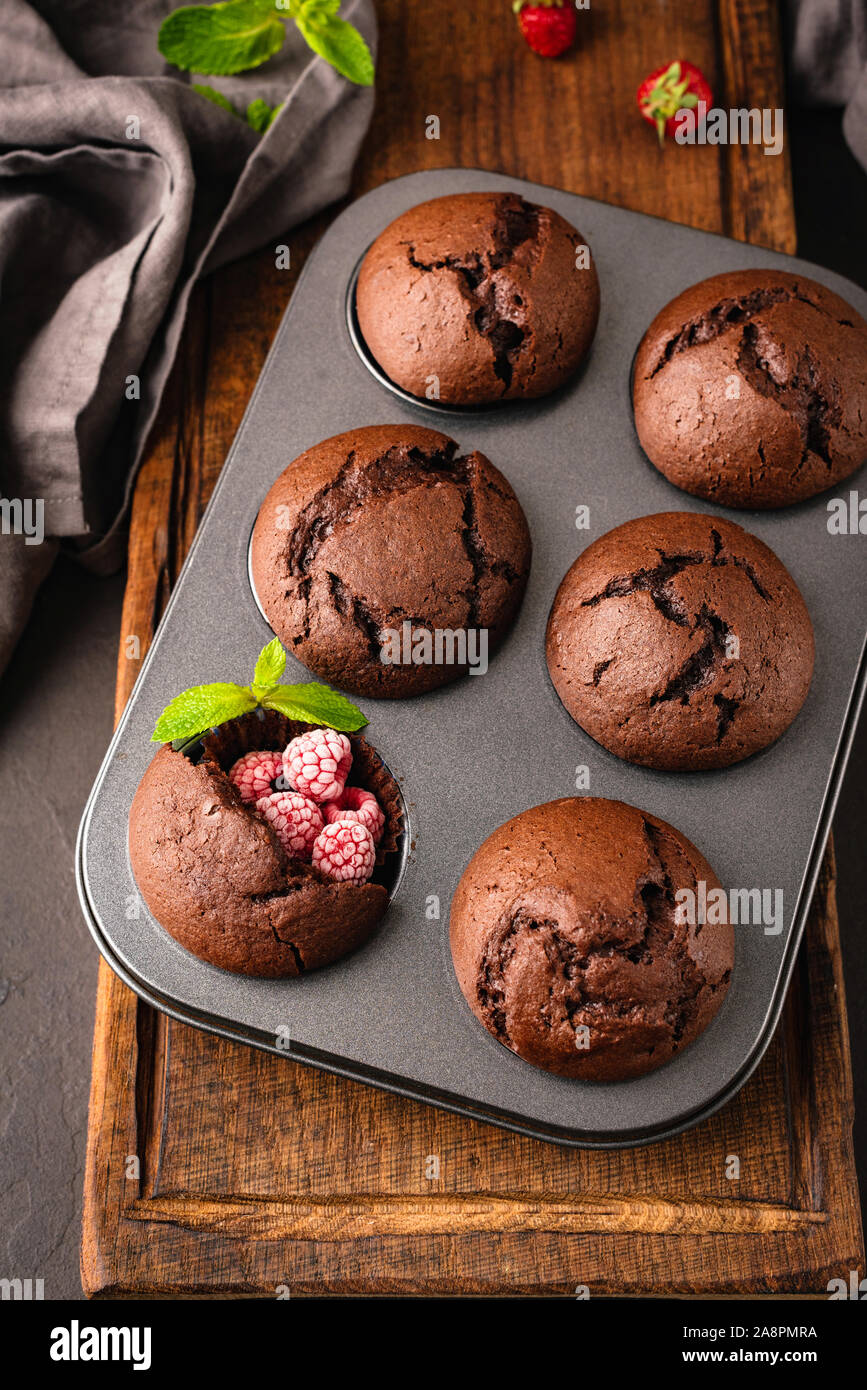 Muffins au chocolat Muffins aux framboises dans un moule métallique, vue de dessus, l'orientation verticale Banque D'Images