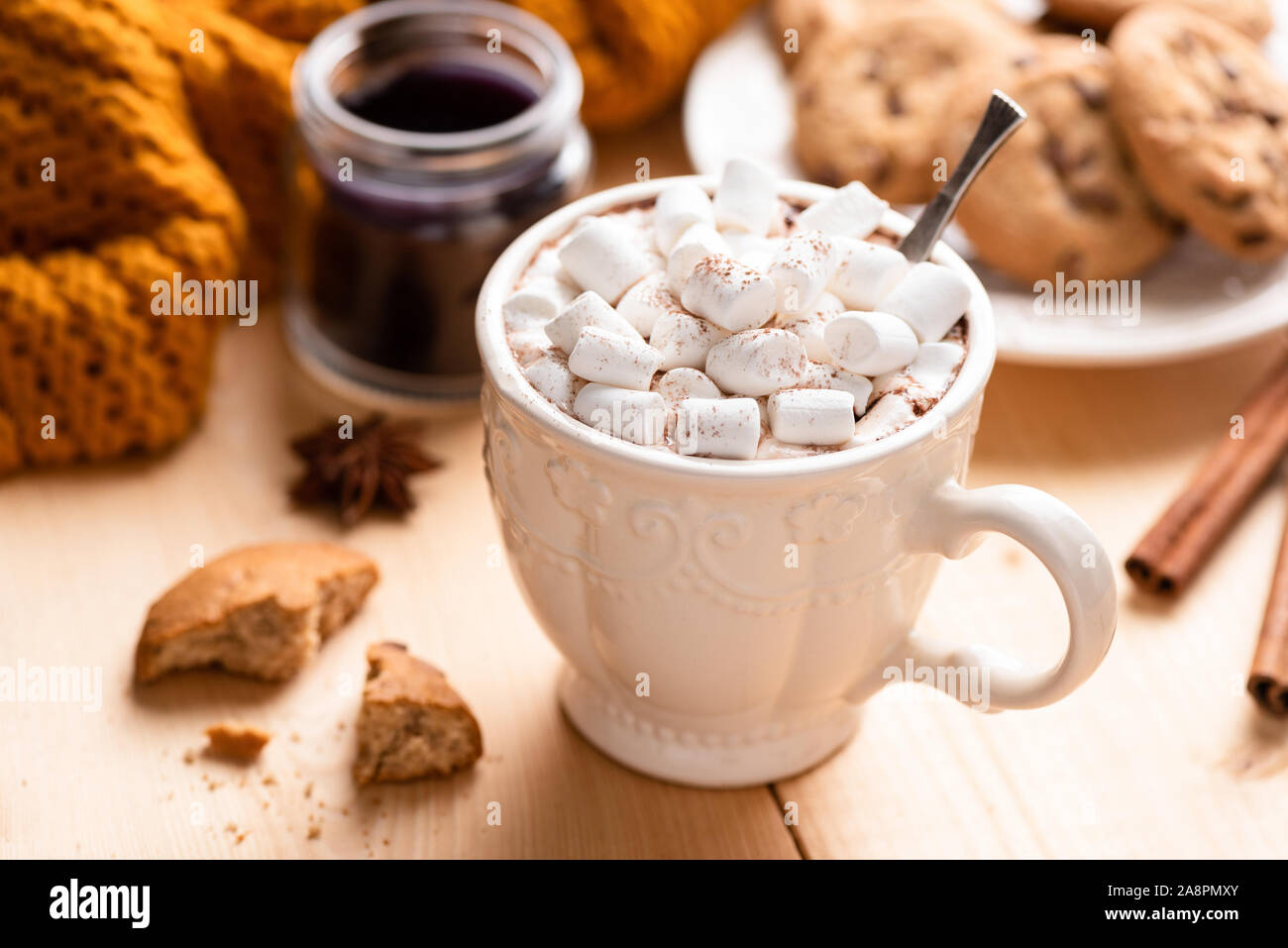 Mug blanc chocolat chaud avec des guimauves sur table en bois. Confort alimentaire Banque D'Images