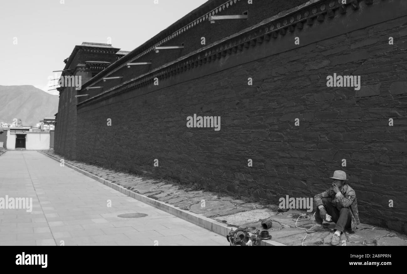 Un jeune travailleur prend une pause de la reconstruction au monastère de Labrang, Chine Banque D'Images