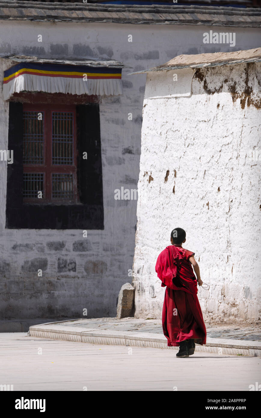 Un moine novice tournant à la rue du monastère de Labrang, Chine Banque D'Images