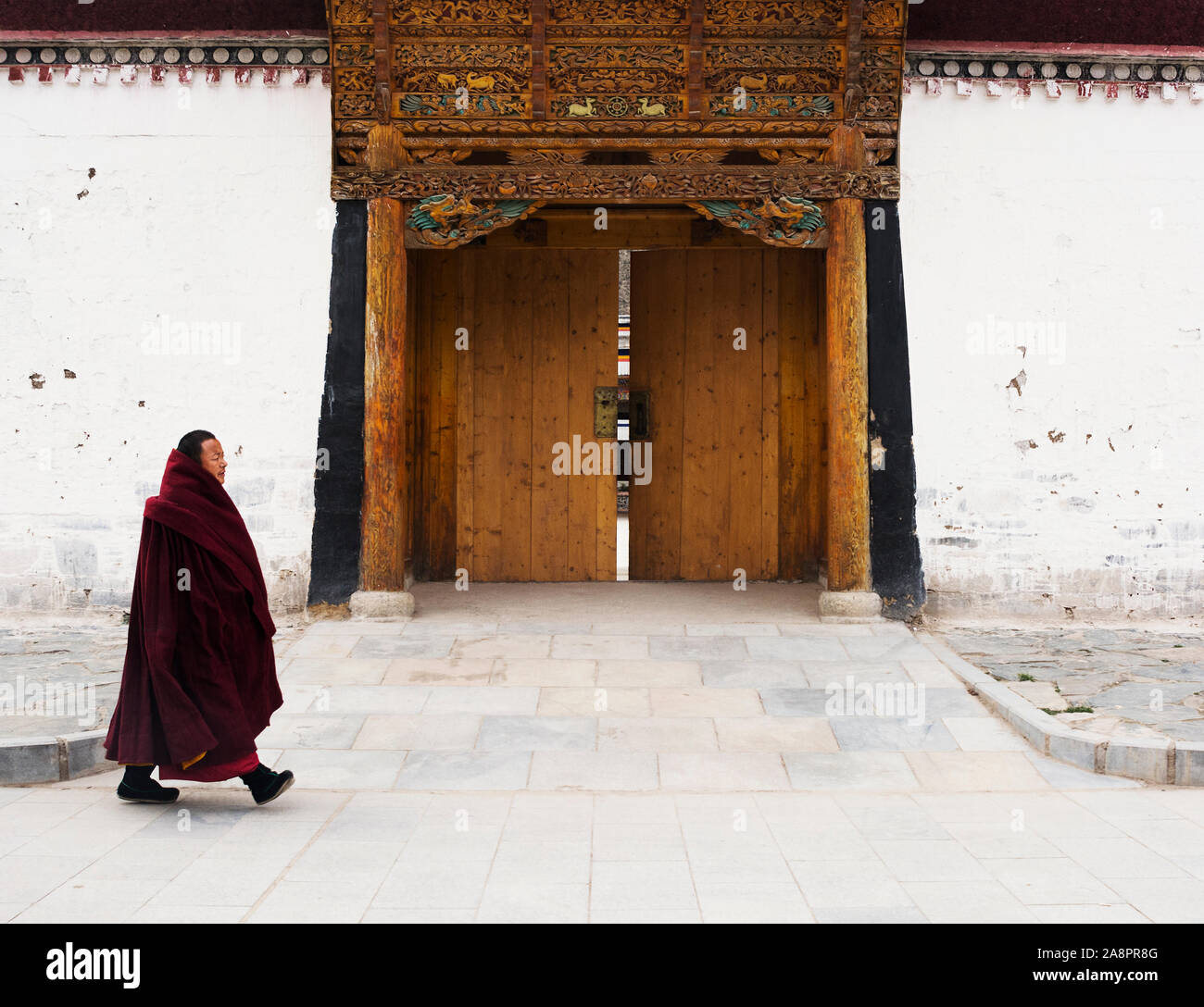 Un moine revient à la maison après l'après-midi de débat religieux, Labrang, Chine Banque D'Images