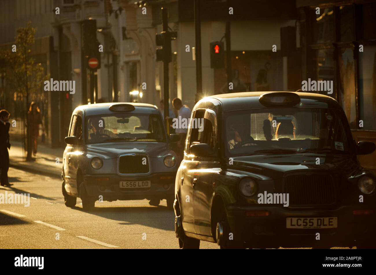 Londres - 30 SEPTEMBRE 2011 : deux taxis noirs, également appelés Voitures Hackney, conduisent au soleil de l'après-midi. Banque D'Images