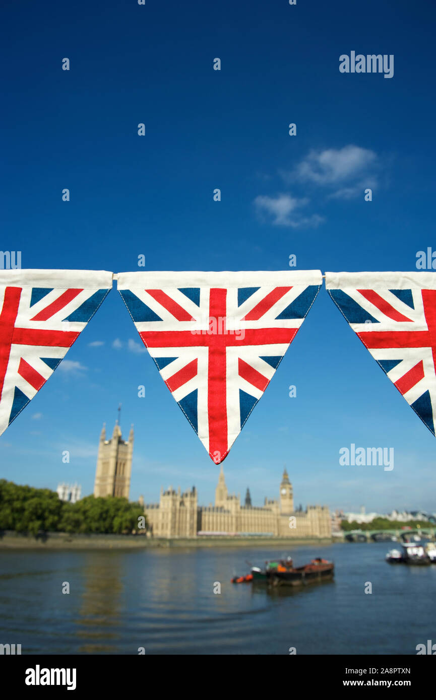 Chaîne d'Union Jack flag bunting accroché en face de Big Ben, dans les chambres du Parlement à Londres, au Royaume-Uni avec ciel bleu copy space Banque D'Images