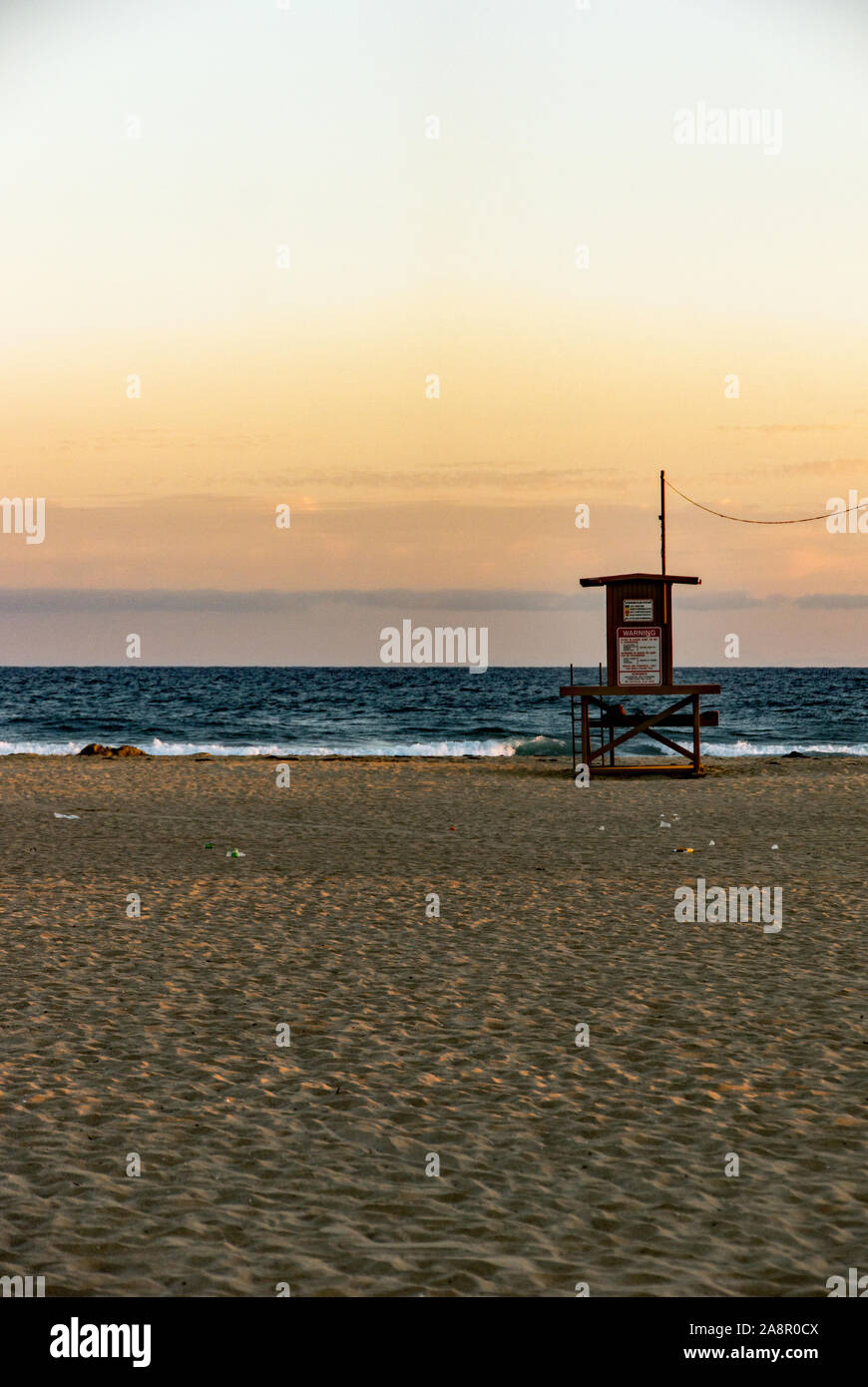 Newport, California/USA- 18 juillet 2019 : un ciel rouge au coucher du soleil sur l'océan Pacifique et d'un seul palmier sur Newport Beach en Californie. Le lifeguar Banque D'Images