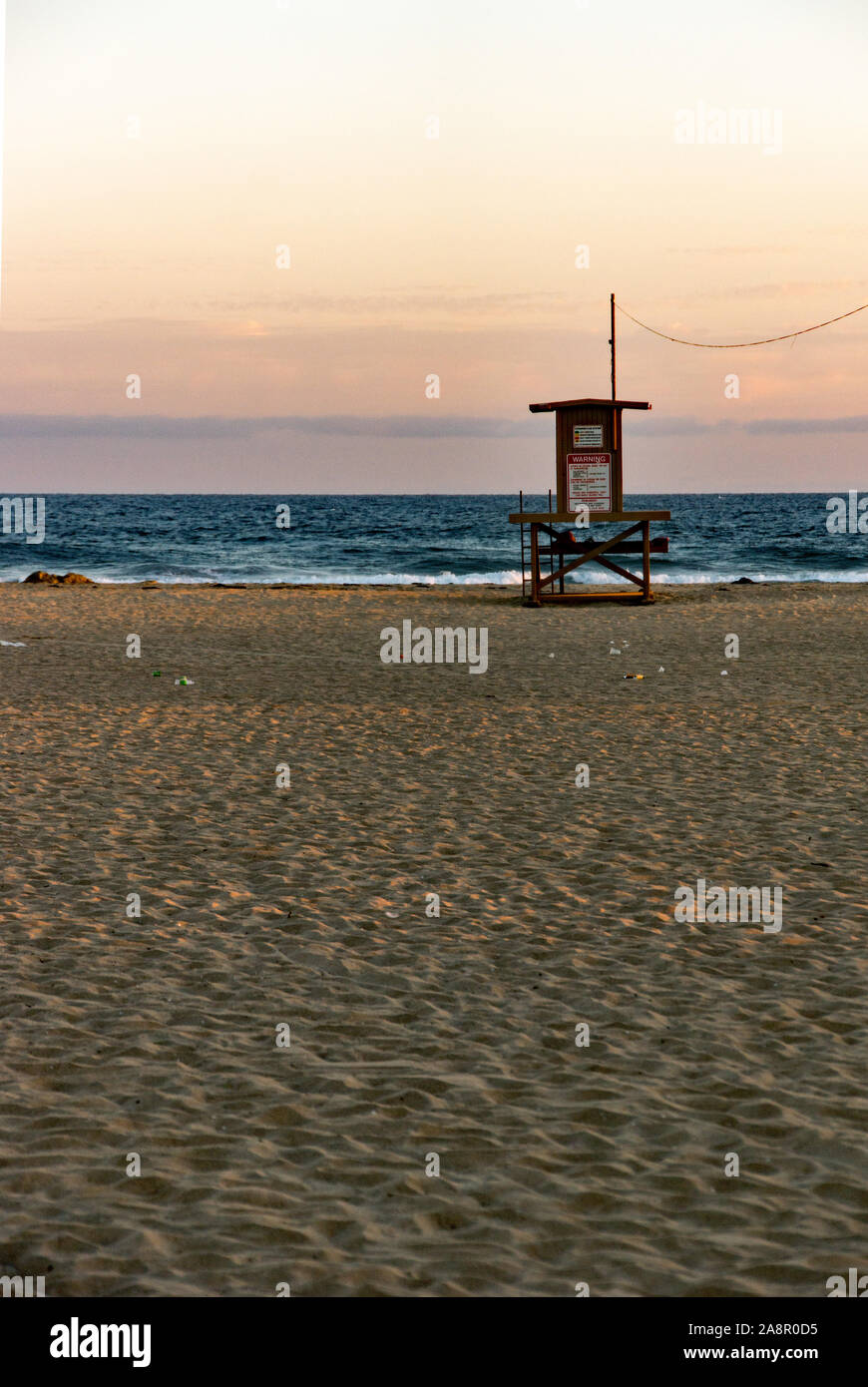 Newport, California/USA- 18 juillet 2019 : un ciel rouge au coucher du soleil sur l'océan Pacifique et d'un seul palmier sur Newport Beach en Californie. Le lifeguar Banque D'Images