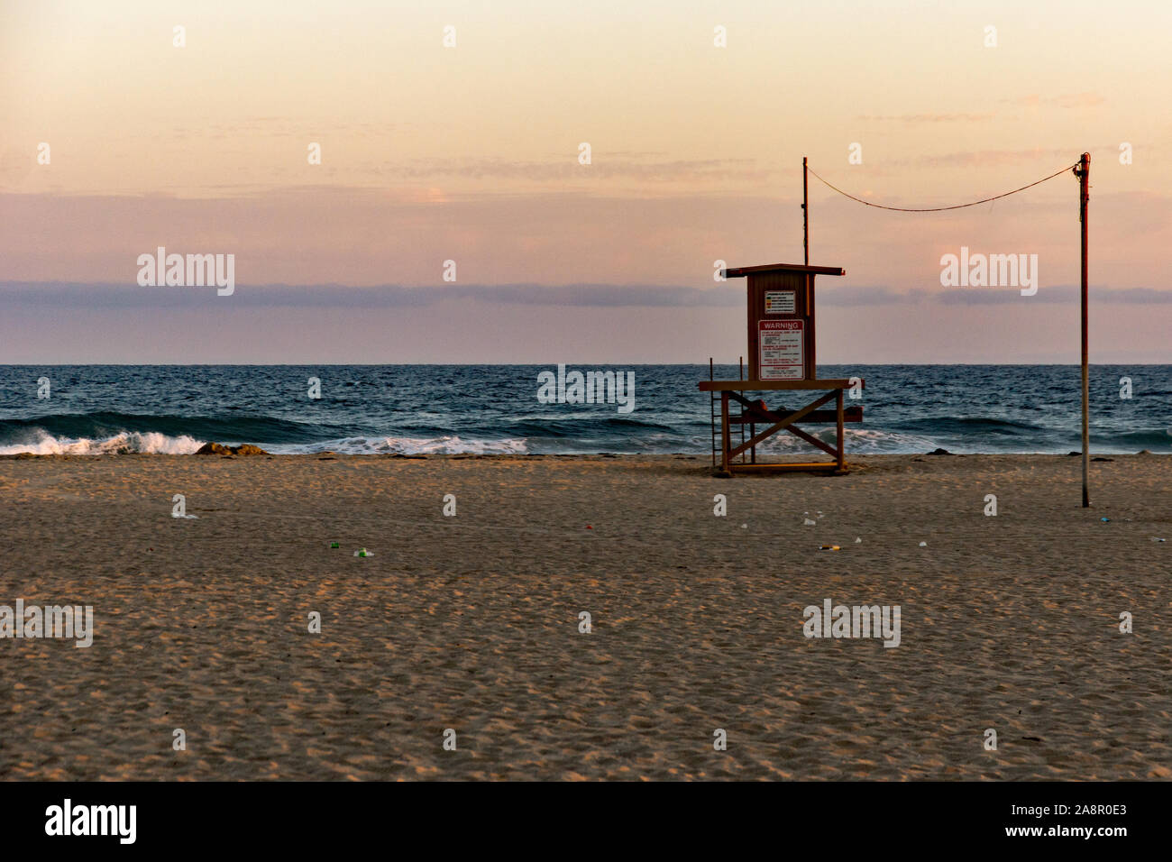 Newport,California/USA- 18 juillet 2019 : un ciel rouge au coucher du soleil sur l'océan Pacifique et d'un seul palmier sur Newport Beach en Californie. Le sauveteur Banque D'Images