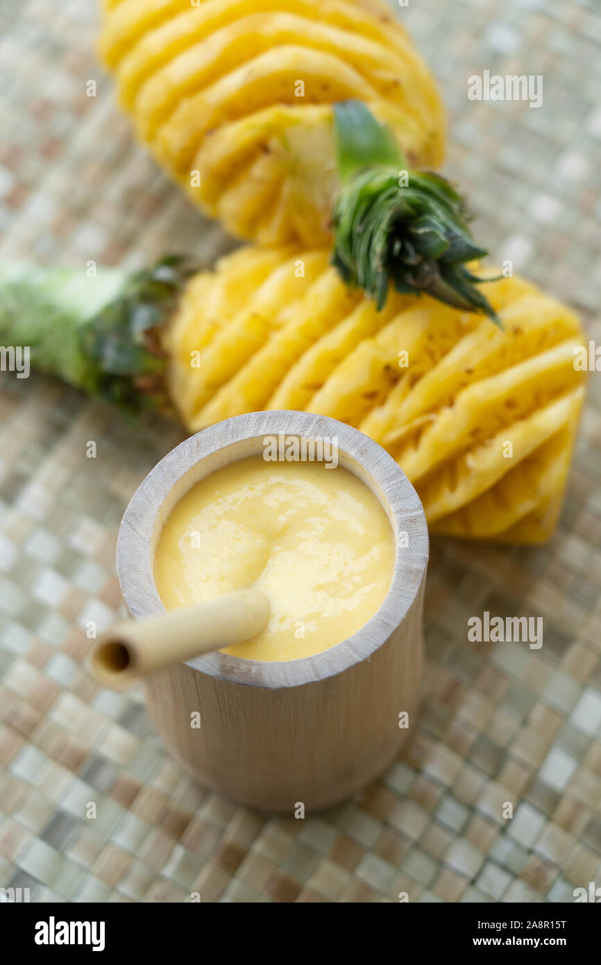 Une simple tasse ancienne en bambou rempli d'un smoothie d'ananas et une paille bambou réutilisables utilisés pour boire.met en lumière l'option d'utiliser le NAT Banque D'Images