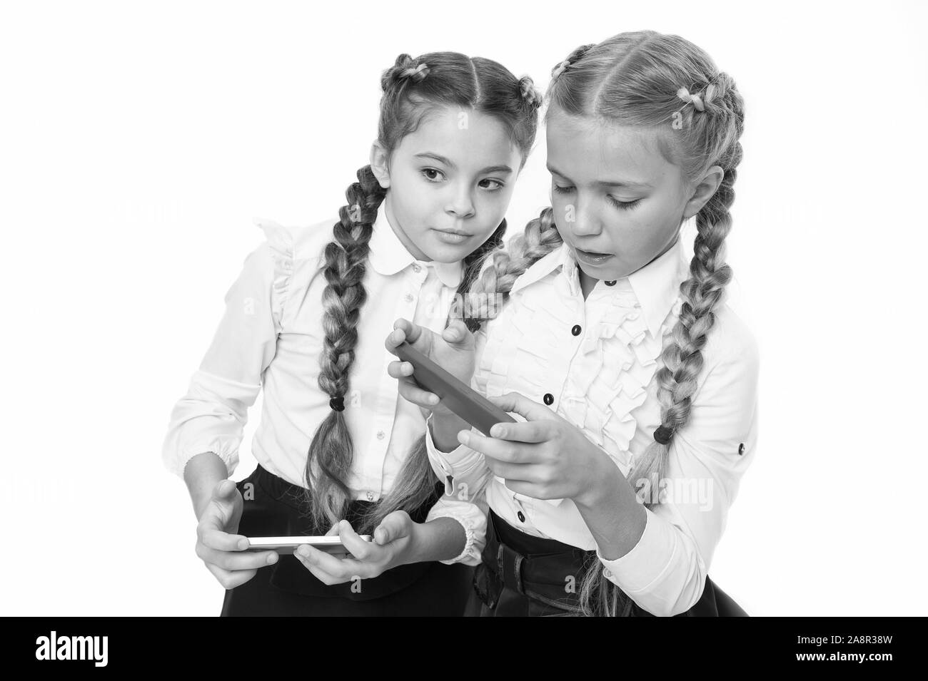 La technologie numérique pour l'enseignement et l'apprentissage. Les petits enfants en utilisant la technologie mobile dans classe isolé sur blanc. La promotion de la technologie dans l'éducation. Les avantages de la technologie de l'éducation. Banque D'Images