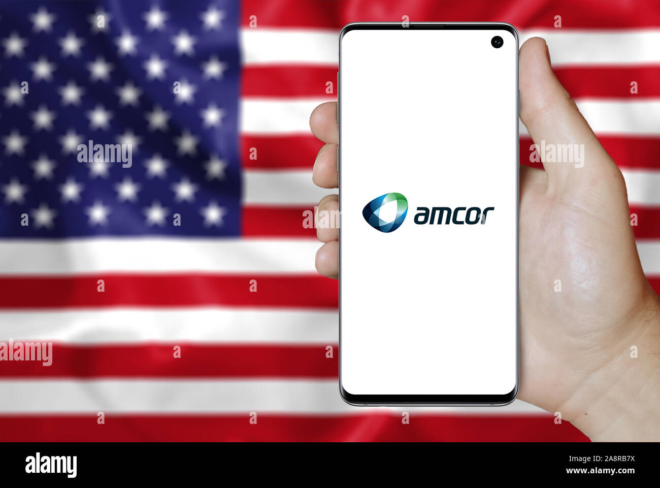 Logo de compagnie publique Amcor plc affichée sur un smartphone. Pavillon de l'USA historique. Credit : PIXDUCE Banque D'Images