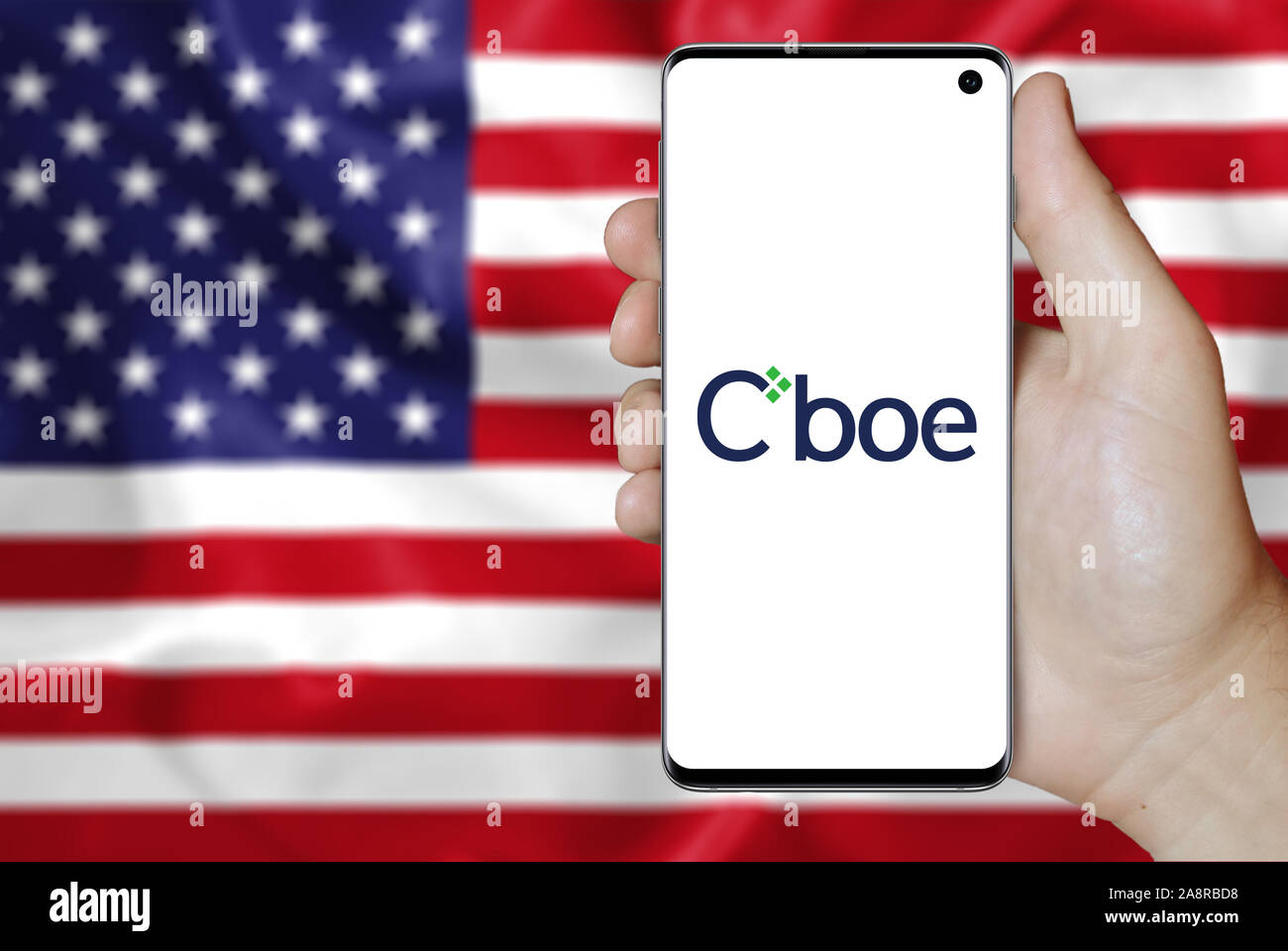 Logo de compagnie publique Cboe Marchés globaux affichés sur un smartphone. Pavillon de l'USA historique. Credit : PIXDUCE Banque D'Images