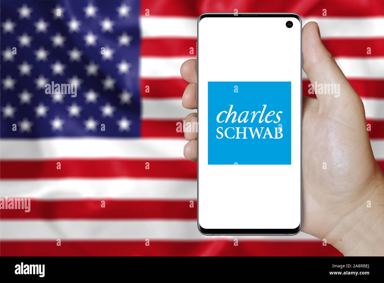Logo de compagnie publique Charles Schwab Corporation affichée sur un smartphone. Pavillon de l'USA historique. Credit : PIXDUCE Banque D'Images