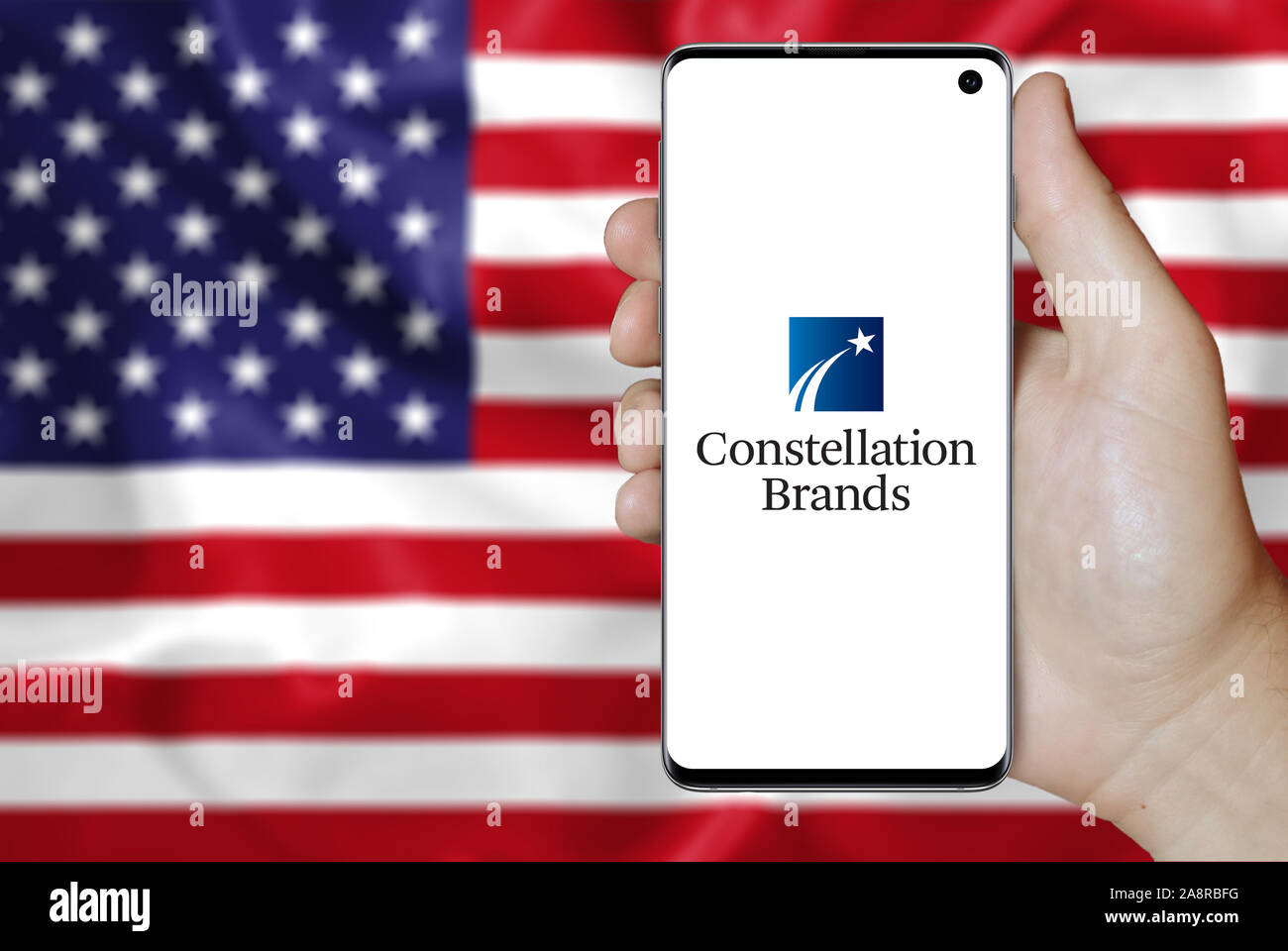 Logo de compagnie publique Constellation Brands affiche sur un smartphone. Pavillon de l'USA historique. Credit : PIXDUCE Banque D'Images
