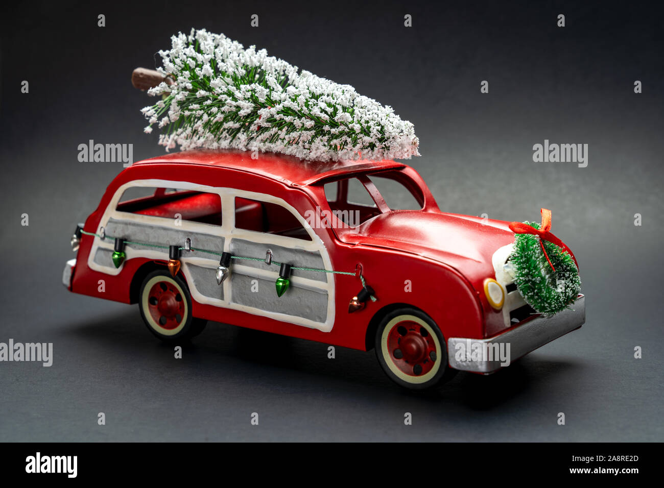 Little red vintage voiture transportant un arbre de Noël sur le dessus Banque D'Images