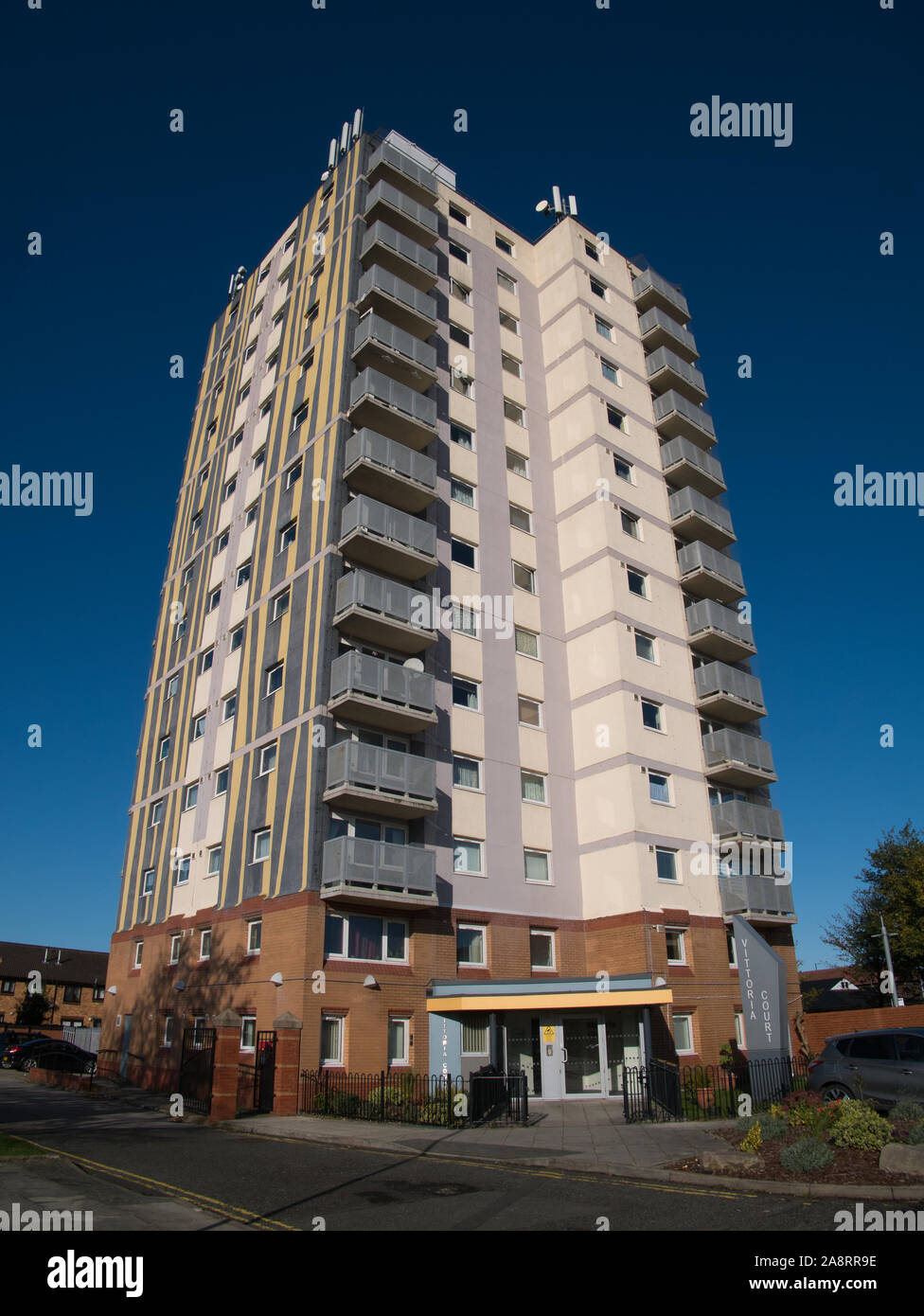 Une tour urbaine du logement social dans le Merseyside au Royaume-Uni, contre un bleu, ciel sans nuages. Banque D'Images