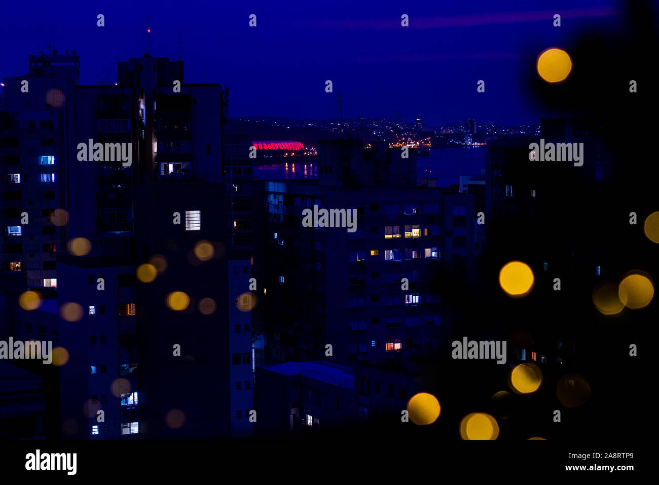 Soir à Porto Alegre, au Brésil, avec des lumières de Noël reflétée sur une fenêtre. Banque D'Images