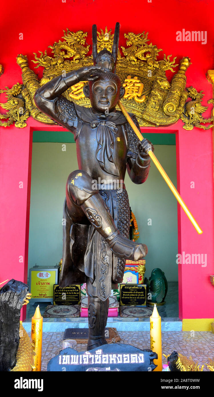 Une statue de Roi singe avec un mur rouge vif il behine et or l'écriture chinoise. Banque D'Images