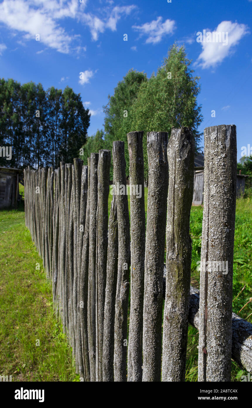 Clôture en bois moussus ordinaire dans le typique style russe ancien sur une claire journée d'orientation verticale Banque D'Images