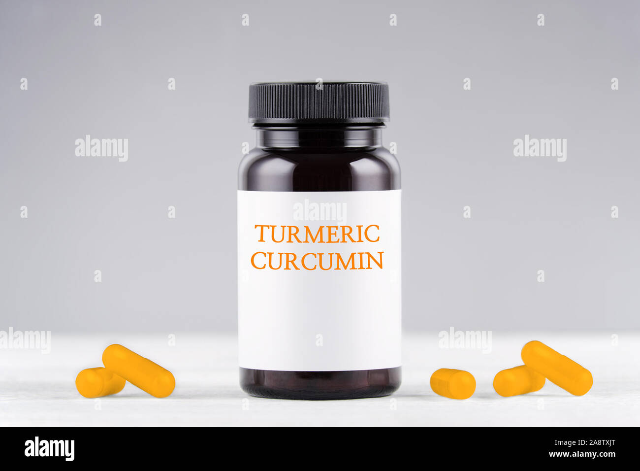 Complément nutritionnel curcumine Curcuma Gélules et bouteille sur gris Banque D'Images