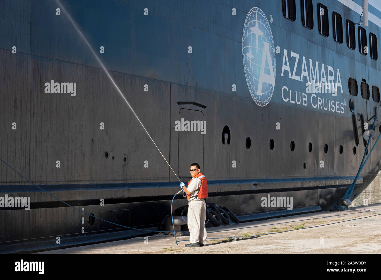 Un membre d'équipage se lave le côté du bateau de croisière Azamara Journey tandis qu'au port de Kotor, Monténégro. Banque D'Images