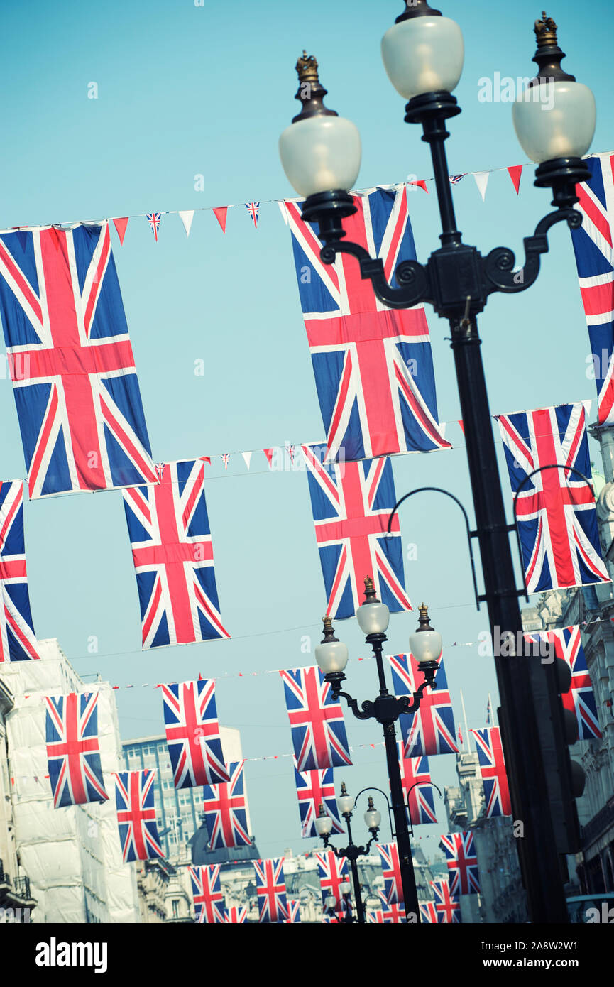 Drapeaux Union Jack britannique accroché verticalement dans le ciel bleu tendre à Londres, Royaume-Uni Banque D'Images