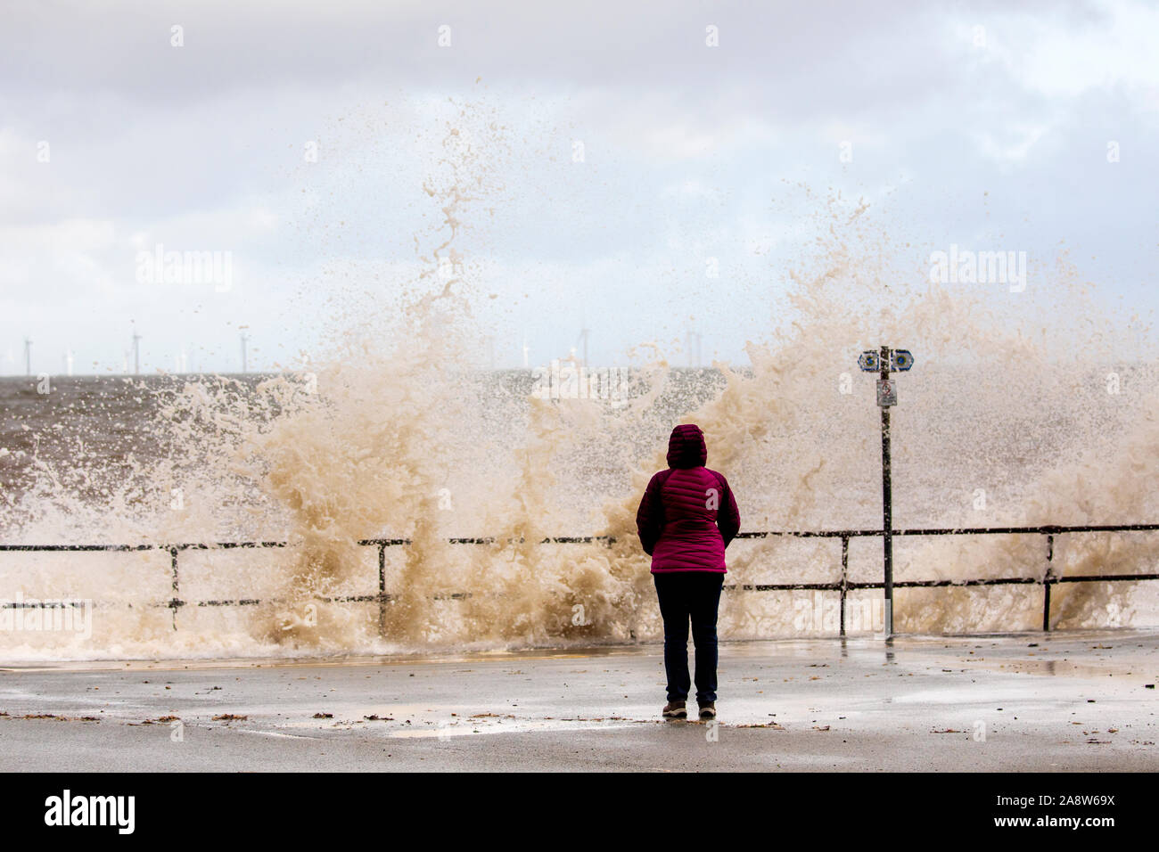 Colwyn Bay, au nord du Pays de Galles, Royaume-Uni. 11 novembre 2019.UK temps pluvieux et venteux de nombreuses aujourd'hui avec des conditions dangereuses sur le littoral avec de hautes marées causant des vagues énormes comme vu à Colwyn Bay, dans le Nord du Pays de Galles comme cette vague watcher découvert Crédit : DGDImages/Alamy Live News Banque D'Images