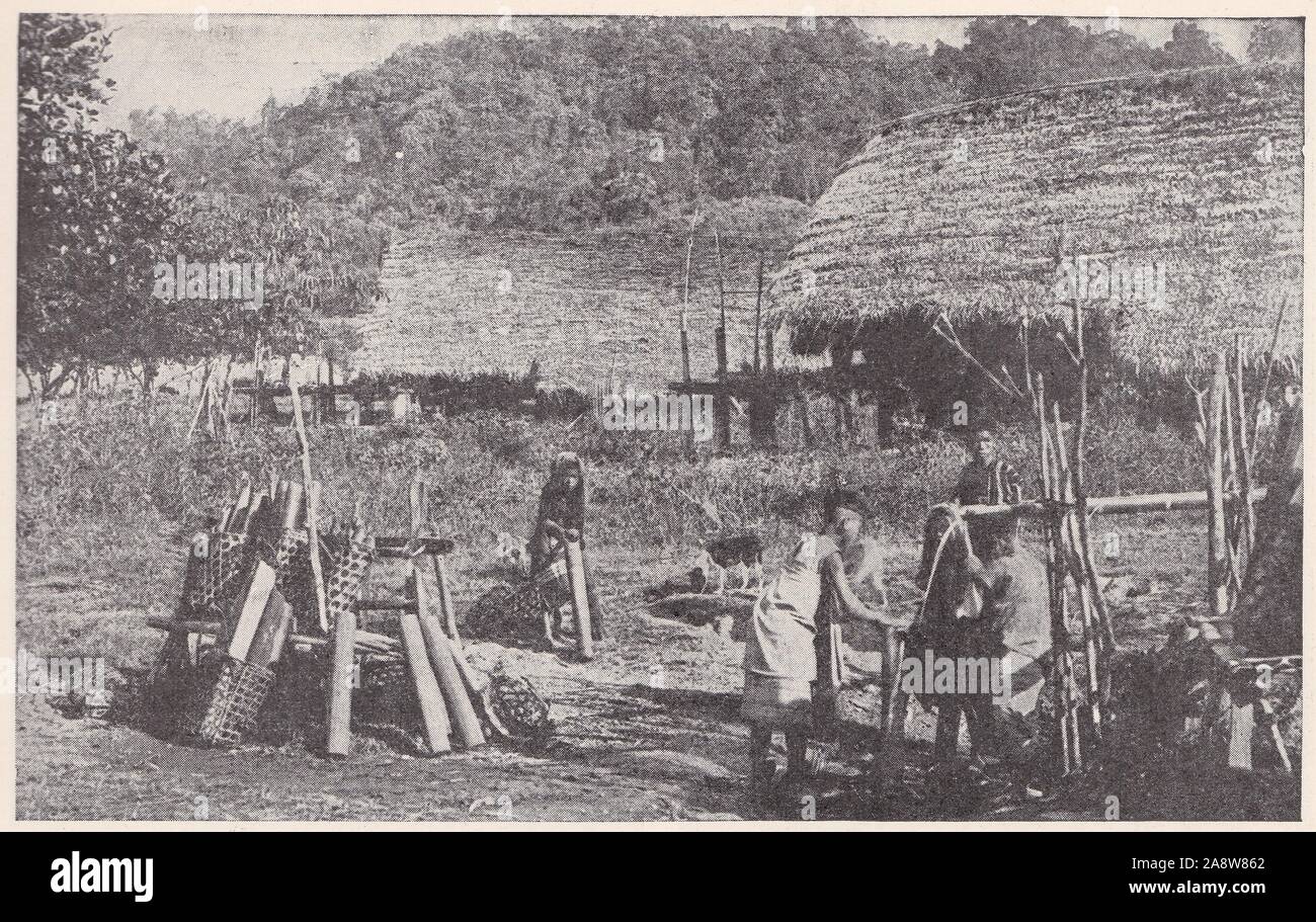 Village natal 'Pump' montrant de nombreuses utilisations du bambou. L'eau étant transportées dans des tubes de bambou 1940 / 1950. Banque D'Images