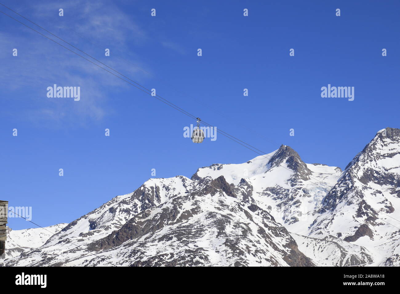 Gondola en passant en face de montagnes alpines en neige et ciel bleu. Banque D'Images