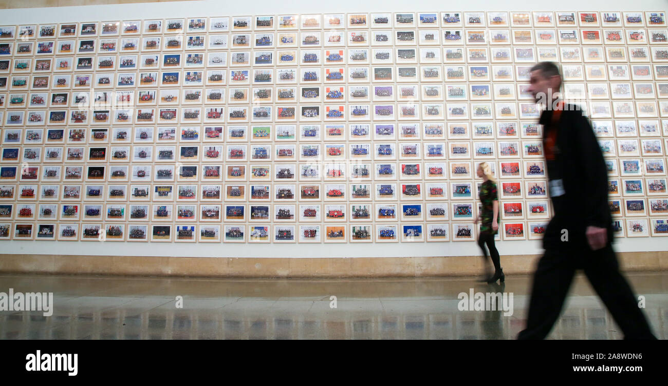 Londres, Royaume-Uni. 11Th Nov, 2019. Un membre du personnel de l'aperçu vues Steve McQueen Année 3 Exposition à la Tate Britain. Une installation de plus de 3 000 photographies de classe qui tapissent le mur de Tate BritainÕs Nerval Galeries, représentant plus de 70 000 élèves de l'année 3 écoles primaires par LondonÕs Turner Prize-winning artiste et cinéaste ayant remporté un Oscar, Steve McQueen. L'exposition s'ouvre le 12 novembre au 3 mai 20120. Credit : Dinendra Haria/Alamy Live News Banque D'Images