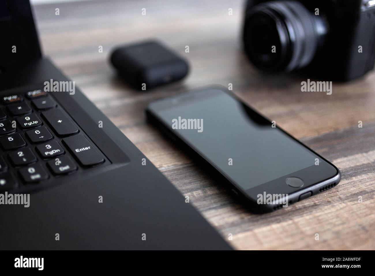 Photographe ou stock photography concept, appareil photo numérique et ordinateur portable noir près de téléphone sur 24 workstation Banque D'Images