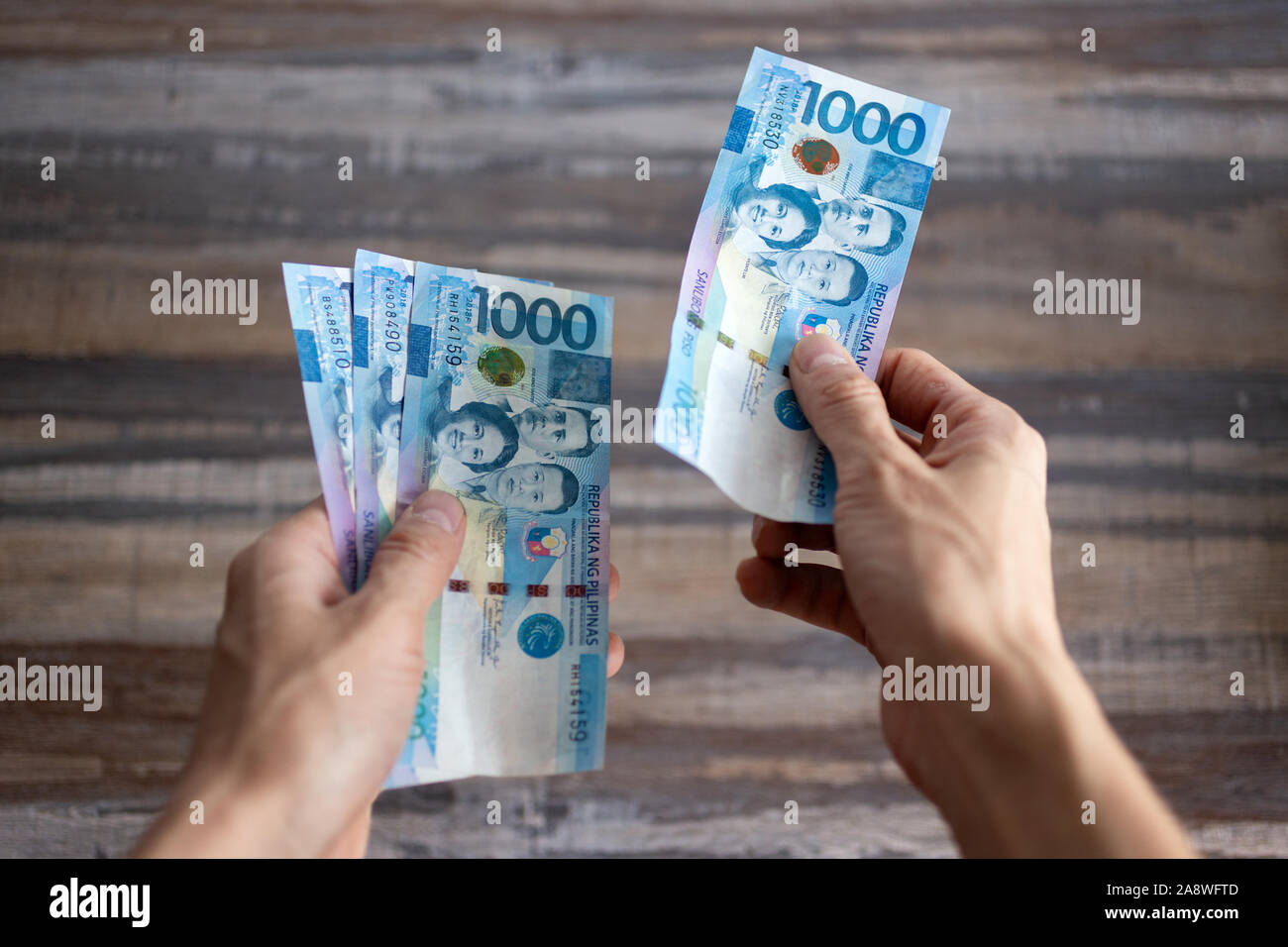 Billet de trésorerie tenir la main de mille Philippines peso le paiement de factures, procédure de paiement ou pot-de, salaire Banque D'Images