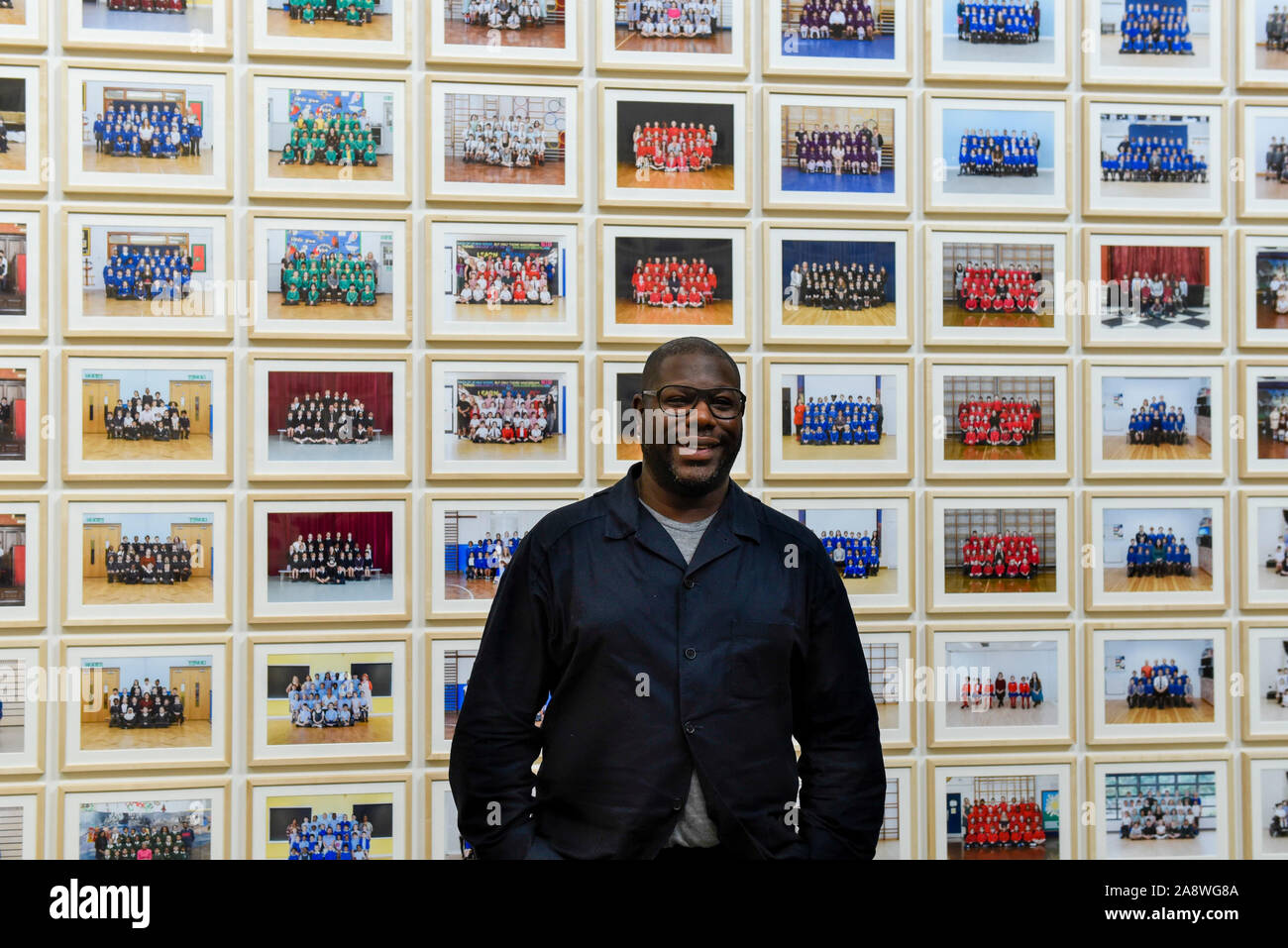 Londres, Royaume-Uni. 11 novembre 2019. Turner Prize-winning artiste et cinéaste oscarisé Steve McQueen pose à l'aperçu de l'Année '3', sa nouvelle exposition à la Tate Britain. L'œuvre se compose de 3 128 photographies de classe à l'école traditionnelle de l'année 3 élèves de 1 504 écoles primaires de Londres. Le travail reflète une image du présent et est à l'affiche 12 novembre au 3 mai 2020. Crédit : Stephen Chung / Alamy Live News Banque D'Images