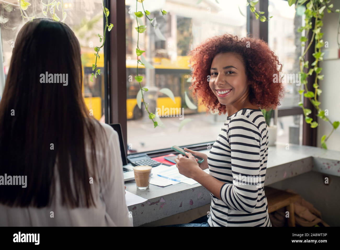 Entrepreneur joyeux sourire tout en travaillant avec des ami Banque D'Images