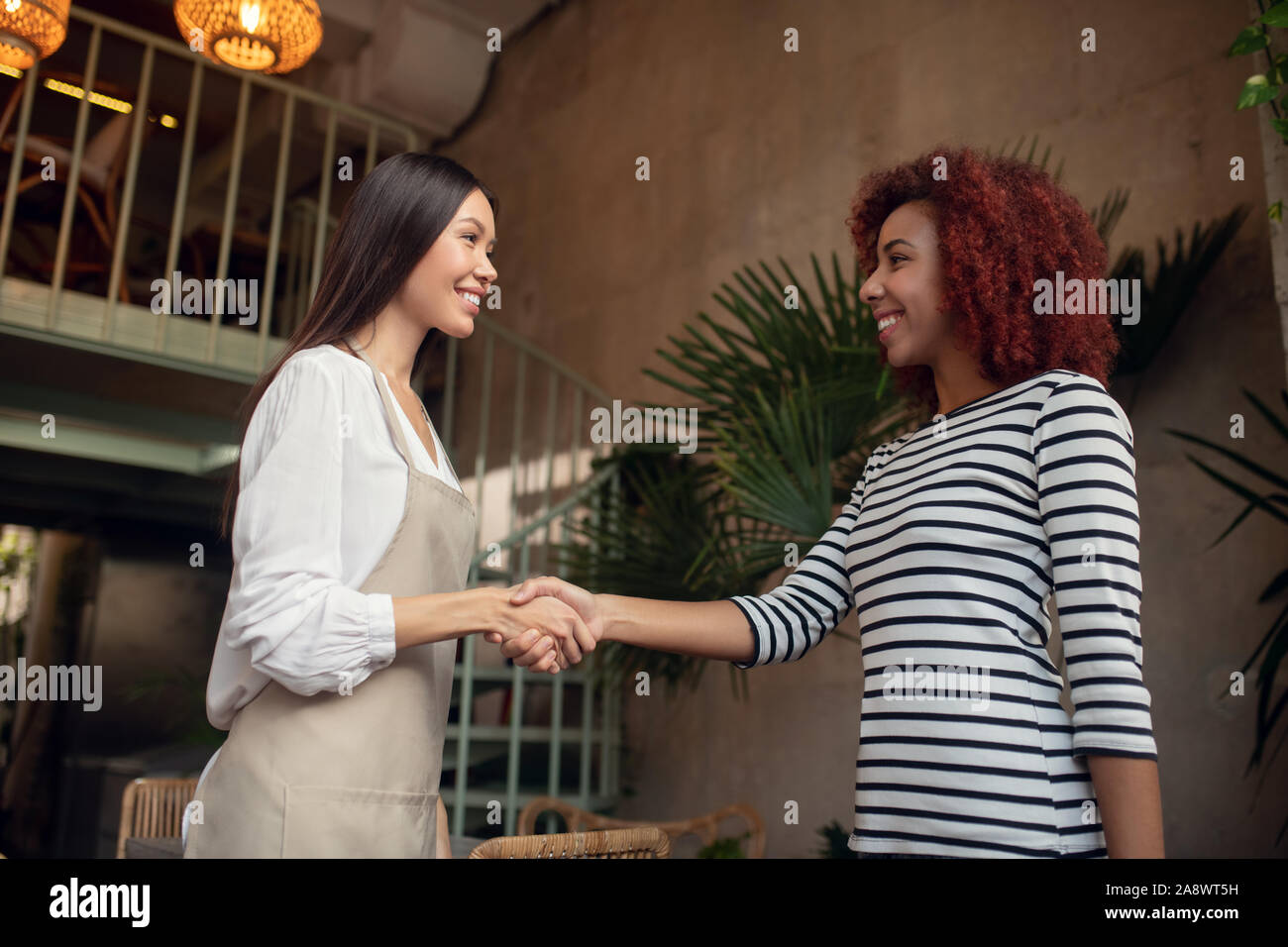 Serveuse main tremblante de son employeur dans la cafétéria Banque D'Images