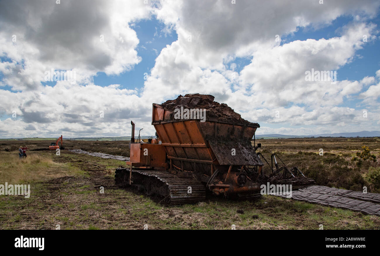 Le comté de Kerry, Irlande - 30 avril 2019 : les hommes et les machines lourdes cultiver tourbière de carburant dans la campagne irlandaise Banque D'Images