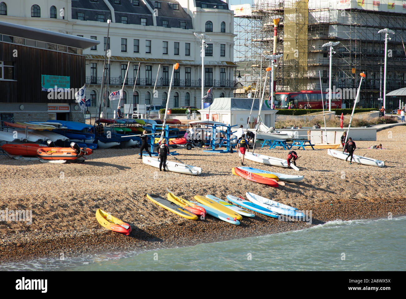Conseils de surf, canoë et les voiliers et les personnes vu sur la plage de Douvres sur une chaude journée ensoleillée à la fin septembre. Banque D'Images
