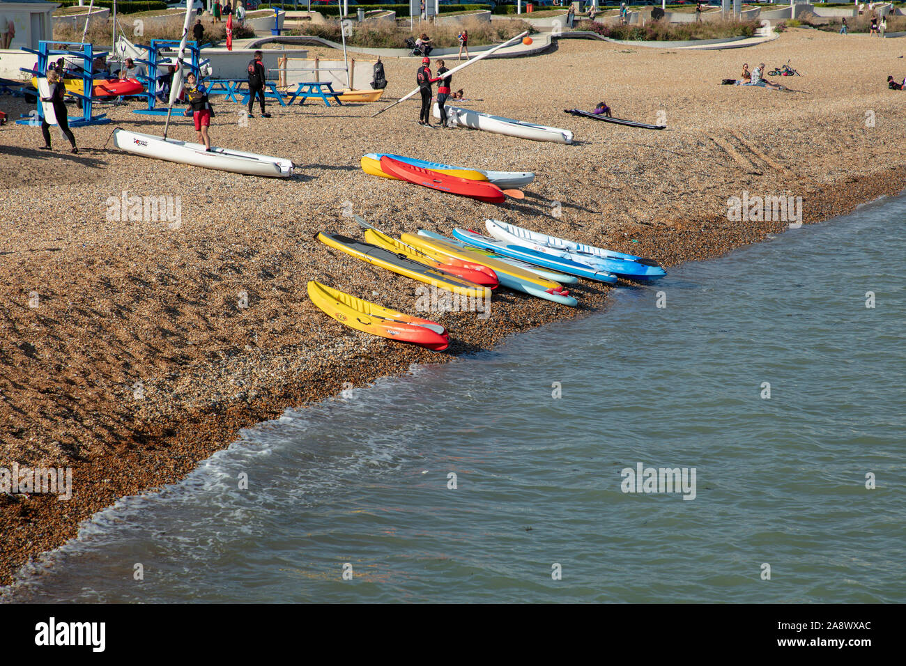 Conseils de surf, canoë et les voiliers et les personnes vu sur la plage de Douvres sur une chaude journée ensoleillée à la fin septembre. Banque D'Images