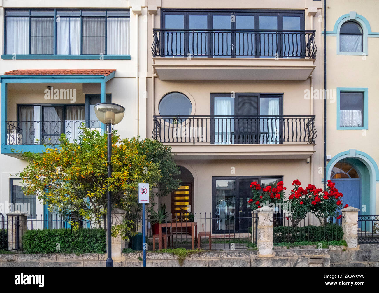 La floraison des roses rouges dans le jardin de devant d'une maison. Banque D'Images