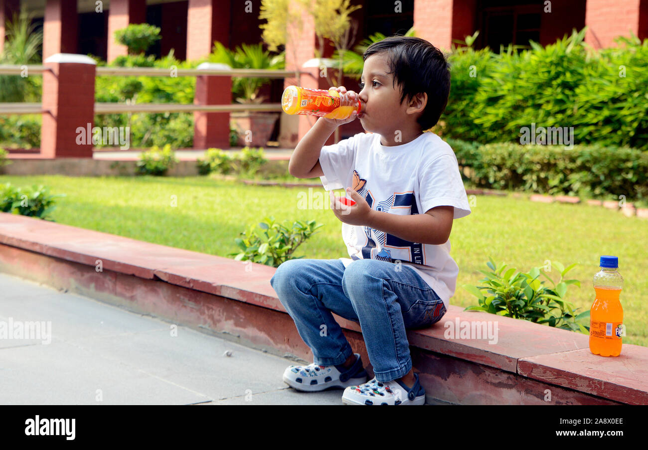 Petit garçon avec une bouteille de jus potable Banque D'Images