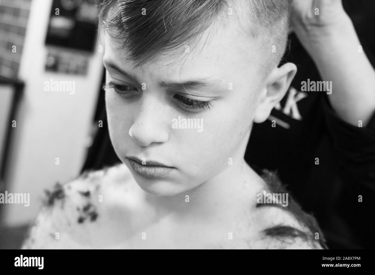 Smiley mignon, beau petit garçon avec TDAH, l'autisme, du syndrome d'Asperger ayant ses cheveux à réaliser dans le salon de coiffure, coiffeur, esthéticienne Banque D'Images