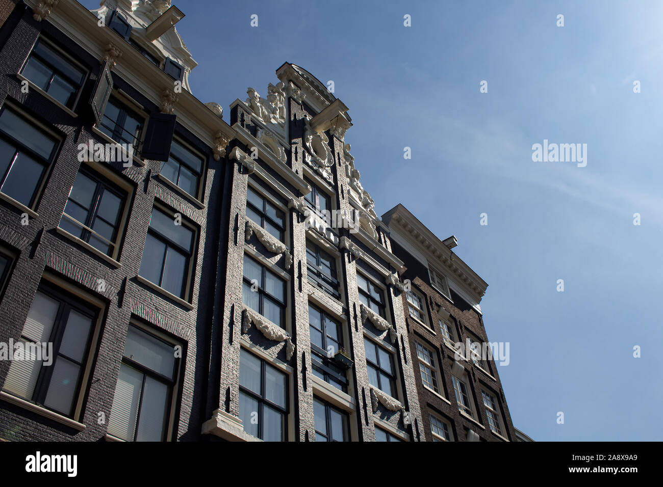 Vue de dessous, historiques et traditionnels de bâtiments typiques montrant un style architectural Néerlandais à Amsterdam. Il s'agit d'une journée ensoleillée. Banque D'Images