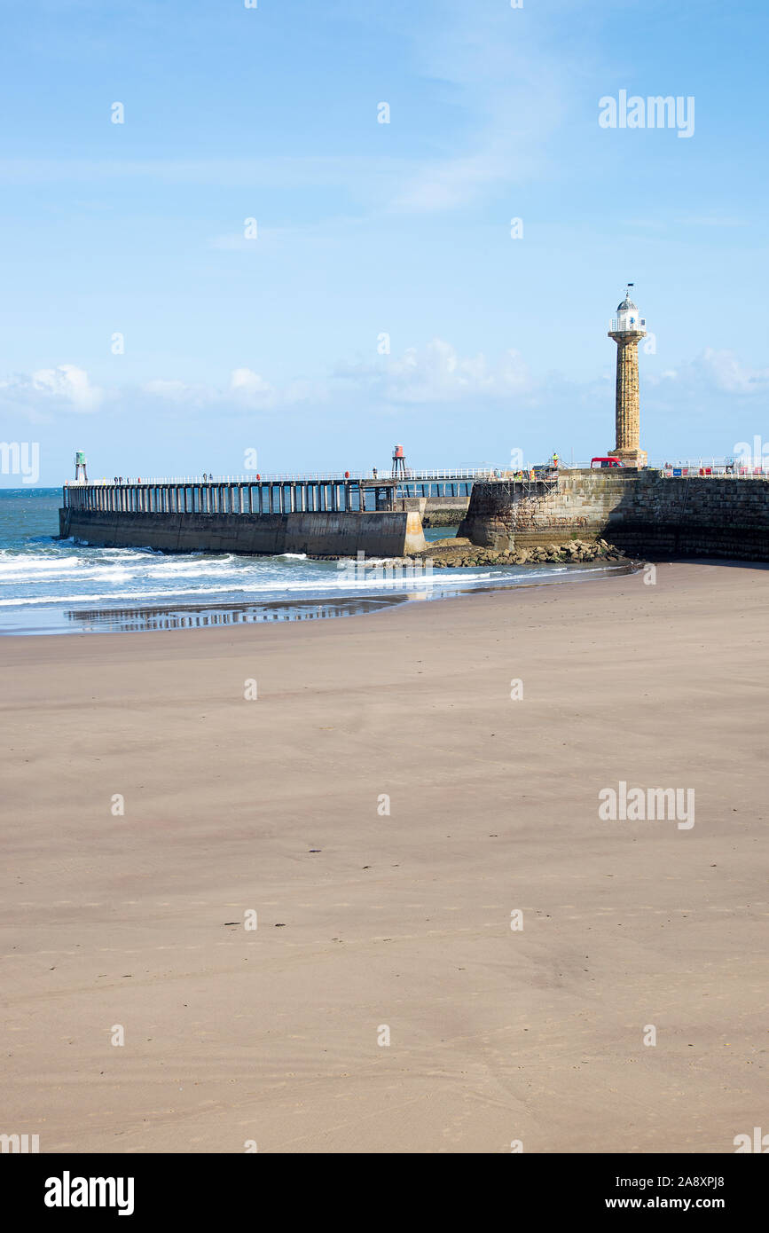 La belle plage de sable, à Whitby, en collaboration avec Sea Wall et l'entrée de l'estuaire de la rivière Esk et phare de North Yorkshire Angleterre UK Banque D'Images