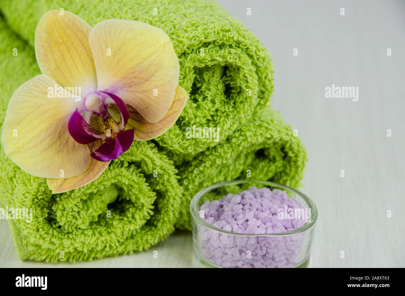 Concept de spa et de bien-être avec orchidée, fleur de sel minéral, et serviettes vert Banque D'Images