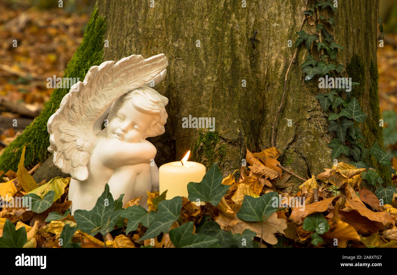 Ange avec bougie dans le cimetière de la forêt Banque D'Images