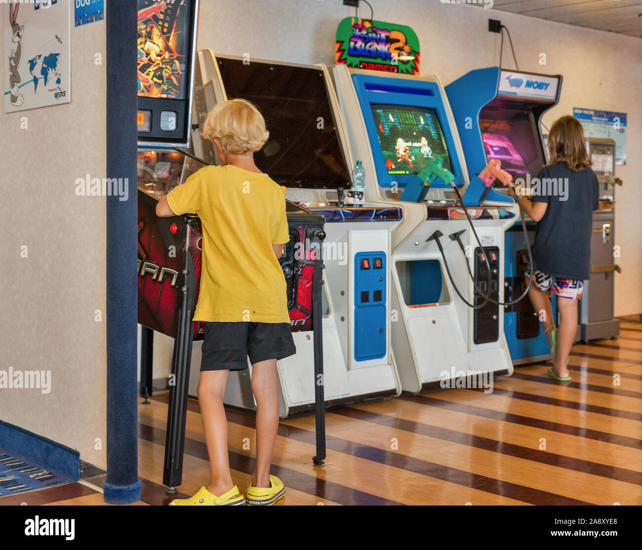 Mer Méditerranée - Juillet 23, 2019 : Garçon et fille joue sur les jeux de combat arcade machine à sous sur Moby ferry navire à passagers. Banque D'Images