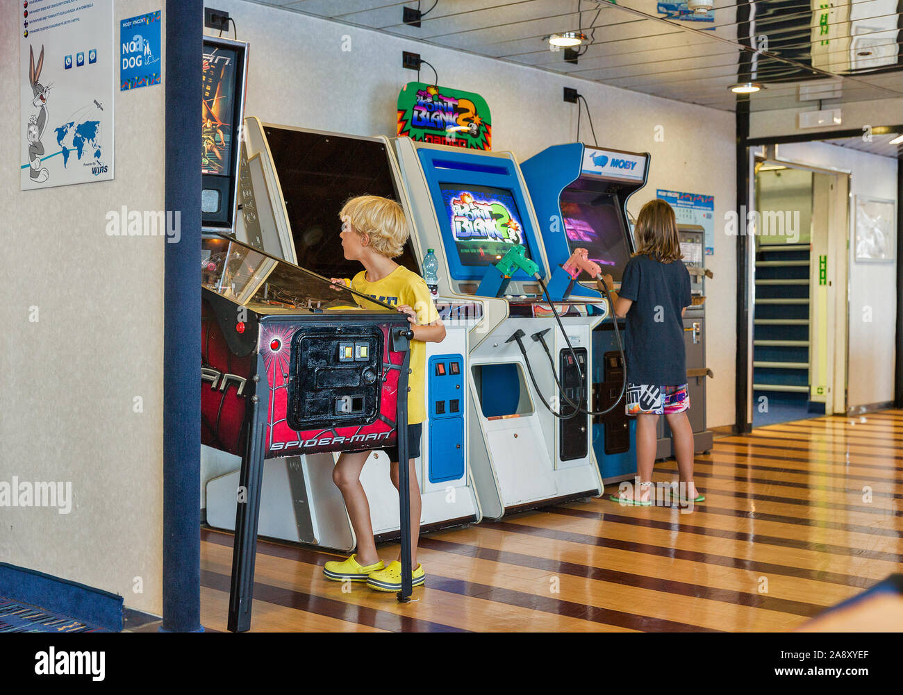 Mer Méditerranée - Juillet 23, 2019 : Garçon et fille joue sur les jeux de combat arcade machine à sous sur Moby ferry navire à passagers. Banque D'Images