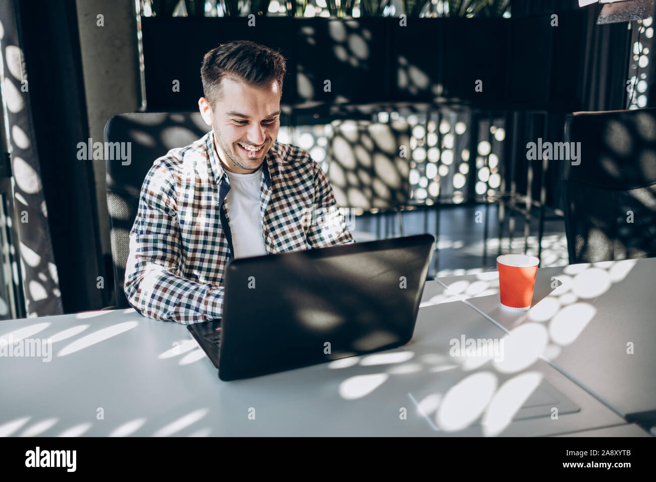 Smiling Freelancer travaillant par ordinateur portable Banque D'Images