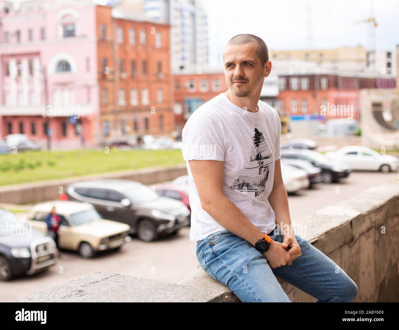 Homme assis dans le parc de la ville et à la route Banque D'Images