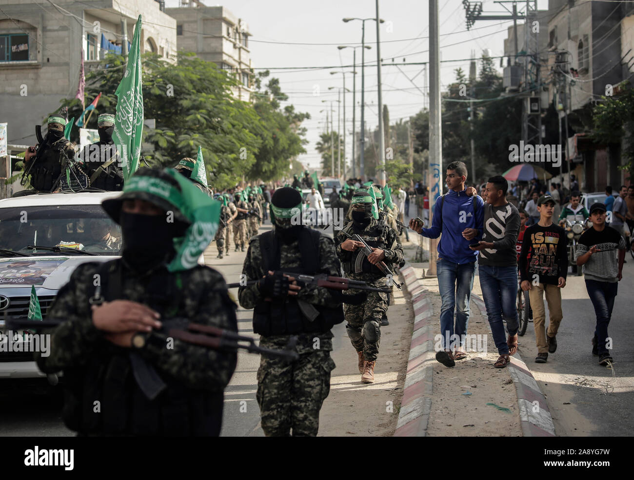 Des jeunes Palestiniens regarder Izz al-Din al-Qassam armés marcher pendant une parade militaire anti-israéliennes dans le sud de la bande de Gaza.Izz el-Deen al-Qassam, la branche armée du mouvement de résistance palestinien Hamas, organiser un show militaire anti-Israël dans le sud de la bande de Gaza dans le cadre de l'anniversaire de la prévention de l'opération israélienne menée dans le Khan Younis, le 11 novembre 2018. Banque D'Images