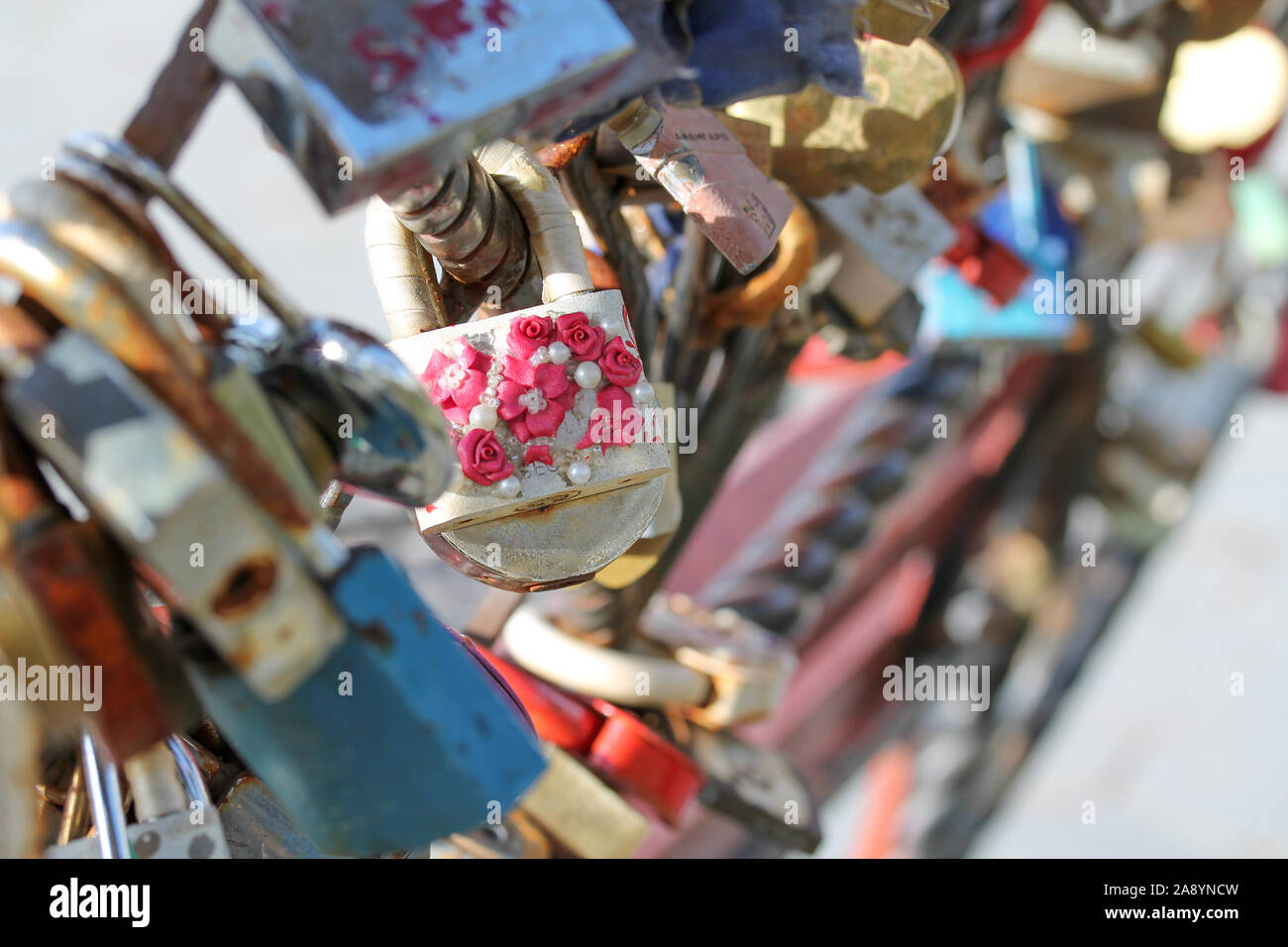 Cadenas de mariage enchaînés à la magistrature en parc de ville. Symbole de l'amour et de la vieille tradition de mariage. Old rusty sweetheart serrures. Photo horizontale de différer Banque D'Images