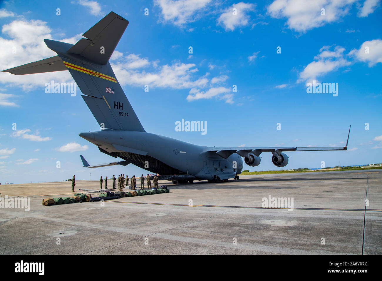 Service des États-Unis avec les membres de l'Escadron d'hélicoptères d'attaque légère Marine 169, 3rd Marine Aircraft Wing (MAW) charger un Corps des Marines américains AH-1Z Cobra d'une U.S. Air Force C-17 Globemaster III au Marine Corps Air Station de Futenma à Okinawa, Japon, le 11 novembre, 2019. L'avion a livré le cobra dans le cadre d'un semi-annuel MAW swap d'aéronefs au sein de l'unité du programme de déploiement. (U.S. Marine Corps photo par Lance Cpl. Karis Mattingly) Banque D'Images